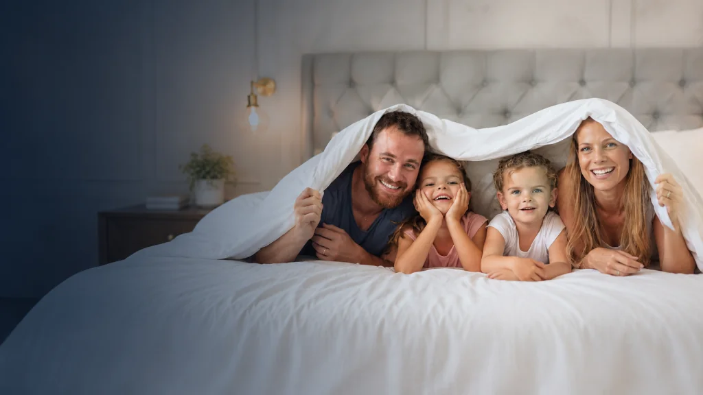 Family relaxing together on a bed in a cozy bedroom