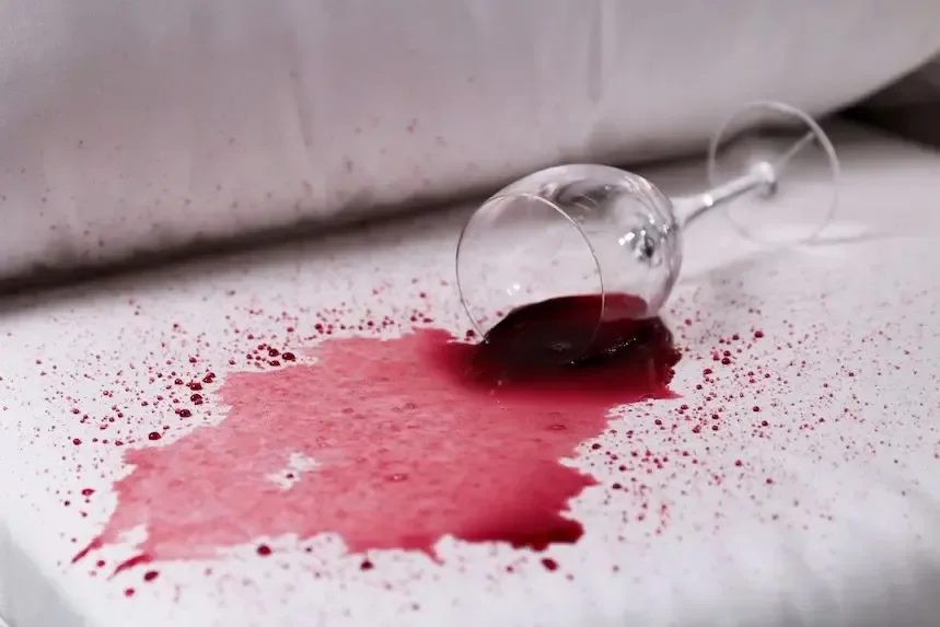 Spilled red wine glass on white fabric