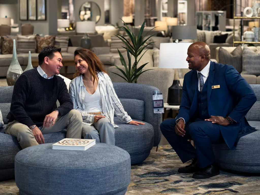 Sales professional assisting a couple in a furniture showroom